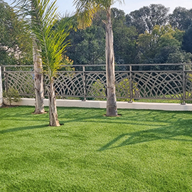 Terrasse en gazon synthétique et palmiers