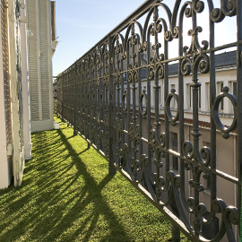 Gazon synthétique sur petit balcon avec rembarde en fer forgé