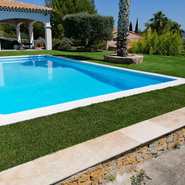 Abords de grande piscine rectangulaire en gazon synthétique