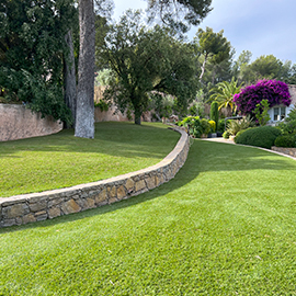 Jardin avec restanques et pelouse artificielle