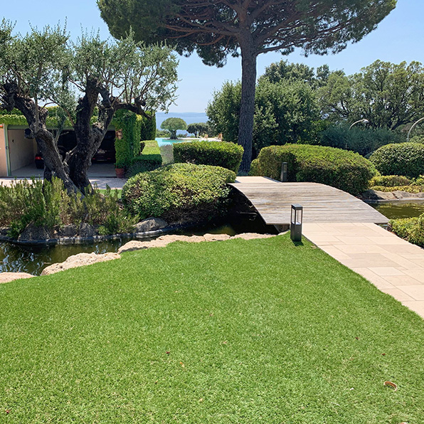Jardin avec faux gazon avec un pont ne bois
