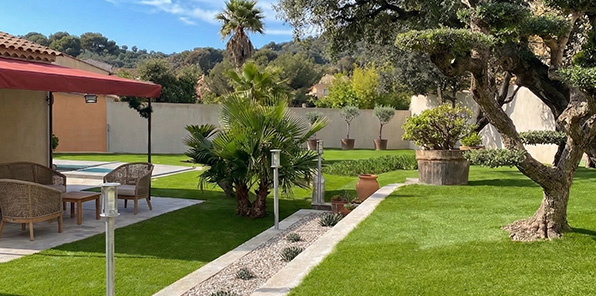 Aménagement paysager d'un grand jardin méditerranéen avec gazon synthétique