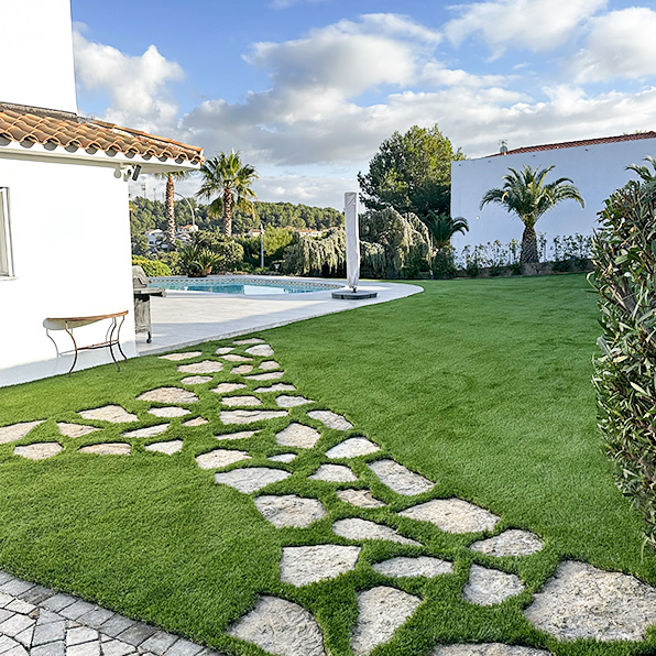 Pose de gazon synthétique autour de dalles en pierre