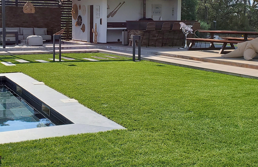 Grand espace extérieur avec piscine, terrasse et fausse pelouse Luxe