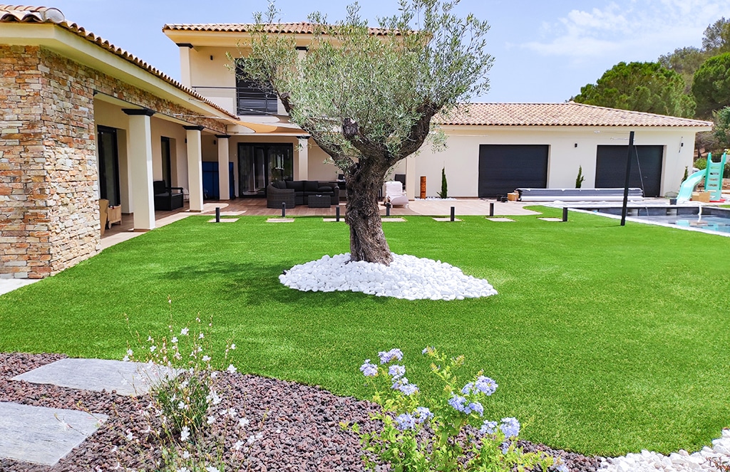 Maison provençale moderne : mur en pierre, jardin, olivier, galet et gazon synthétique