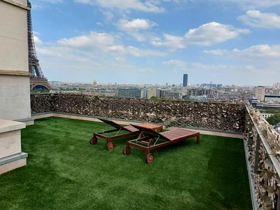 Achat et pose de gazon synthétique à Paris 4 Gazon synthétique posé sur un toit-terrasse à Paris, vue sur les Invalides et la tour Montparnasse