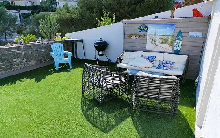 Exemple d'un salon de jardin sur une terrasse avec une pelouse artificielle