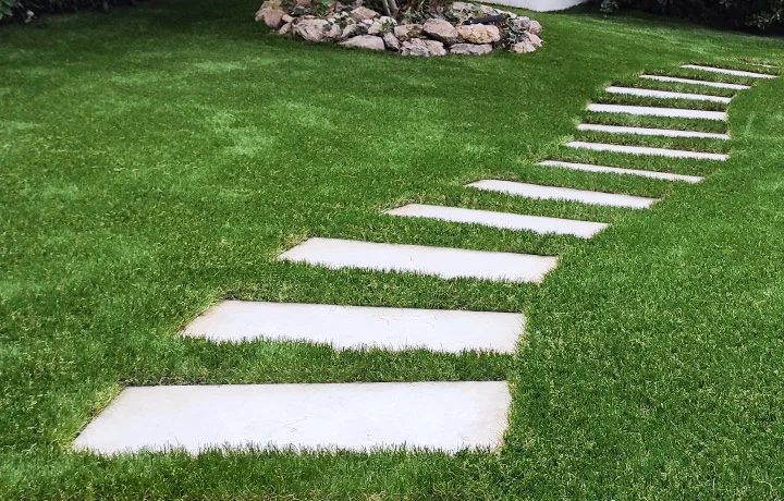 Illustration de découpes de pelouse artificielle autour de dalles béton