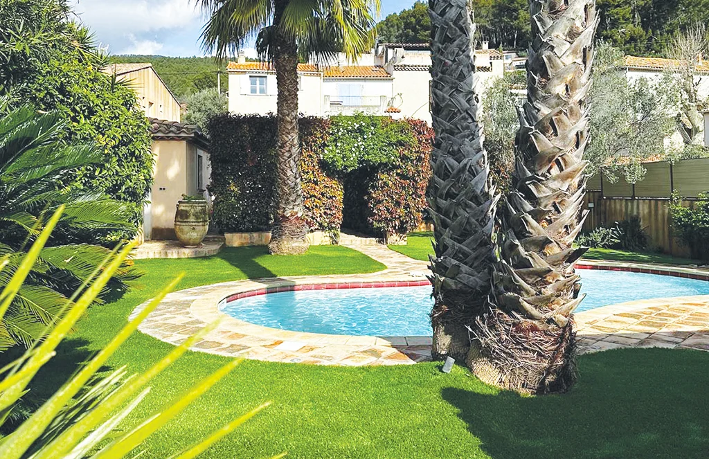 installation de gazon artificiel Saturno 50 autour d'une piscine, dans un jardin